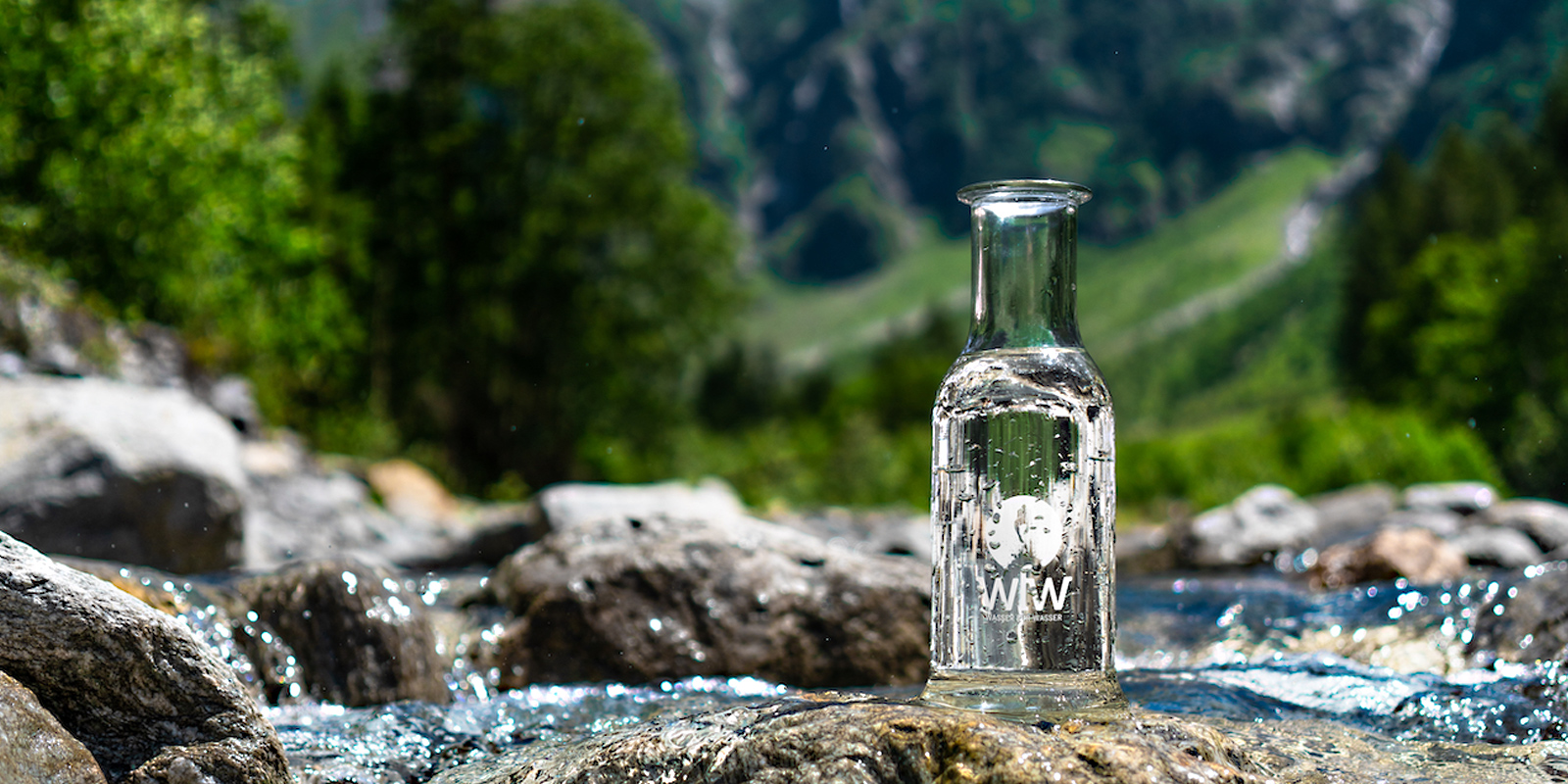 Glasflasche auf einem Stein in einem Fluss