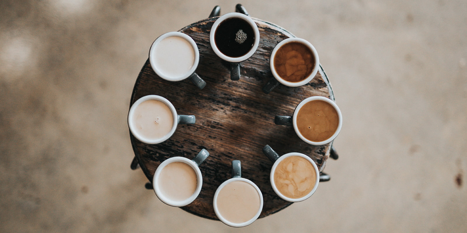 Acht gefüllte Kaffeetassen in einem Kreis angeordnet
